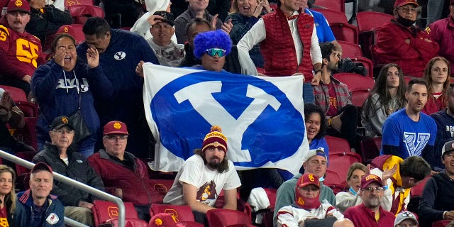 Los Angeles, CA - November 27:  Brigham Young Cougars fans celebrate against the USC Trojans in the first half of a NCAA football game at the Los Angeles Memorial Coliseum in Los Angeles on Saturday, November 27, 2021.