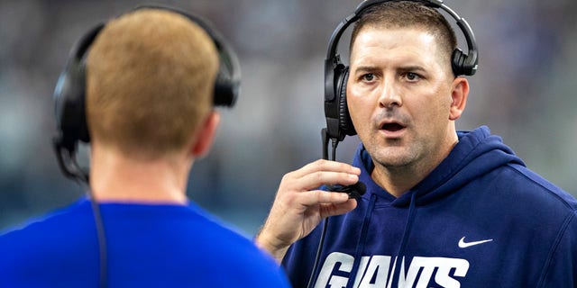 Head Coach Joe Judge talks with offensive coordinator Jason Garrett of the New York Giants during a game against the Dallas Cowboys at AT&T Stadium on October 10, 2021 in Arlington, Texas. The Cowboys defeated the Giants 44-20.