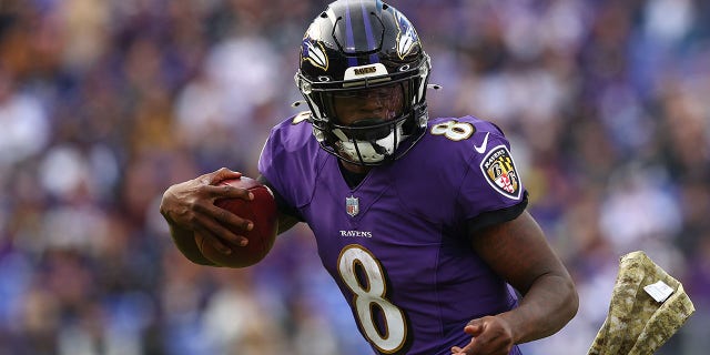 Quarterback Lamar Jackson # 8 do Baltimore Ravens corre a bola contra o Minnesota Vikings no segundo quarto no M&T Bank Stadium em 7 de novembro de 2021 em Baltimore, Maryland.