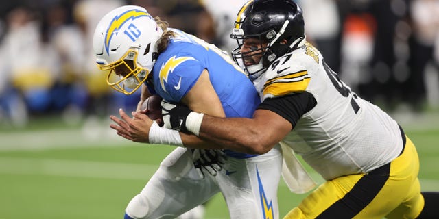 Justin Herbert #10 of the Los Angeles Chargers is tackled by Cameron Heyward #97 of the Pittsburgh Steelers during the fourth quarter at SoFi Stadium on November 21, 2021 in Inglewood, California.