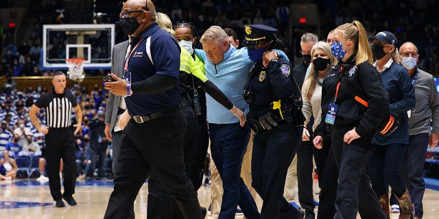 DURHAM, NORTH CAROLINA - NOVEMBER 22: Head coach Duggar Baucom of the Citadel Bulldogs is helped off of the floor after a medical incident during the first half of their game against the Duke Blue Devils at Cameron Indoor Stadium on November 22, 2021 in Durham, North Carolina.