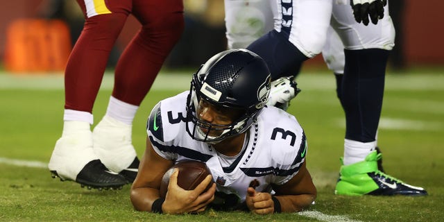 LANDOVER, MARYLAND - NOVEMBRE 29: Russell Wilson #3 of the Seattle Seahawks lies on the field after being sacked in the third quarter against the Washington Football Team at FedExField on November 29, 2021 in Landover, Maryland.