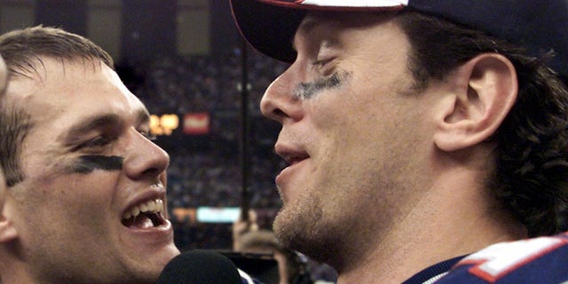 New England Patriots quarterbacks Tom Brady (left) and Drew Bledsoe (right) celebrate their team's victory over the St. Louis Rams Feb. 3, 2002, in Super Bowl XXXVI in New Orleans, Louisiana. 