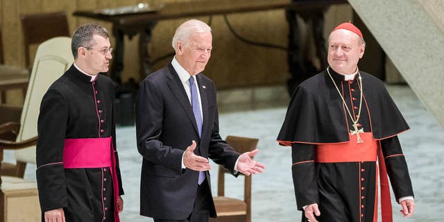 US Vice President Joe Biden (C) is flanked by Cardinal Gianfranco Ravasi (R) as he arrives to attend a special audience celebrates by Pope Francis with participants at a congress on the progress of regenerative medicine and its cultural impact in the Paul VI hall in Vatican City, Vatican on April 29, 2016.(Photo by Giuseppe Ciccia/NurPhoto via Getty Images)