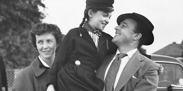 Gene Kelly visiting London with his wife, actress Betsy Blair and daughter Kerry, 1955.