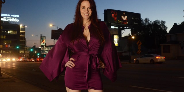 Maitland Ward pose devant son nouveau panneau d'affichage pour