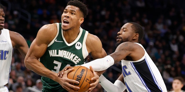 Milwaukee Bucks striker Giannis Antetokounmpo (34) is shot down by Orlando Magic guard Terrence Ross, right, during the first half of an NBA basketball game on Monday, November 22, 2021 in Milwaukee.
