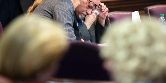 Greg McMichael wipes his eyes during a recess in the testimony of his son Travis McMichael during their trial and trial of their neighbor William "Roddie" Bryan at the Glynn County Courthouse, Wednesday, Nov. 17, 2021, in Brunswick, Georgia. (AP Photo/Stephen B. Morton, Pool)