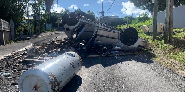 An overturned car is pictured in a s street of Le Gosier, Guadeloupe island, on Sunday, Nov. 21, 2021. 
