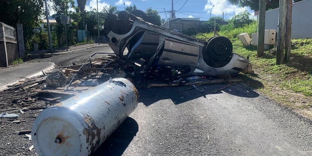 An overturned car is pictured in a s street of Le Gosier, Guadeloupe island, on Sunday, Nov. 21, 2021. 