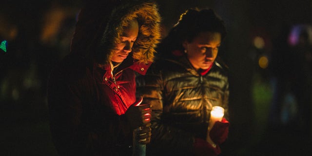 People hold candles during a vigil in Cutler Park on Nov. 22, 2021, in Waukesha, Wisconsin, in honor of those killed and injured during a Christmas parade. 