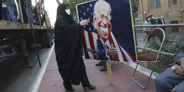 A demonstrator carries a banner with a caricature of the U.S. President Joe Biden in Tehran, Iran, on Thursday. 