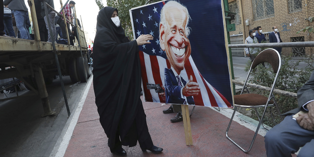 Un manifestant porte une banderole avec une caricature du président américain Joe Biden à Téhéran, en Iran, jeudi.