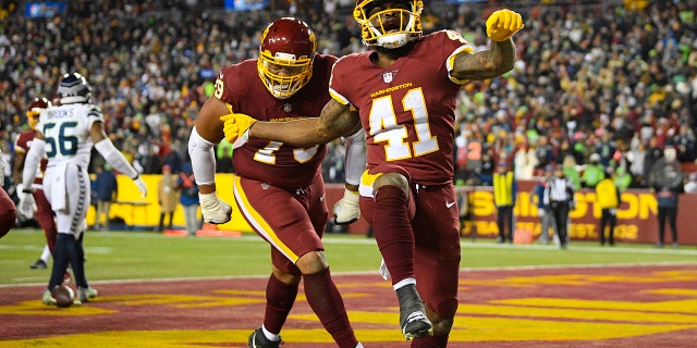 Washington Football Team running back J.D. McKissic (41) celebrating his touchdown against the Seattle Seahawks with teammate guard Ereck Flowers (79) during the second half of an NFL football game, Monday, Nov. 29, 2021, in Landover, Md.