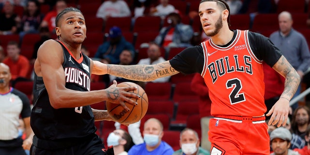 Houston Rockets guard Jalen Green (0) drives to the basket under pressure from Chicago Bulls guard Lonzo Ball (2) during the first half of an NBA basketball game Wednesday, November 24, 2021, in Houston.