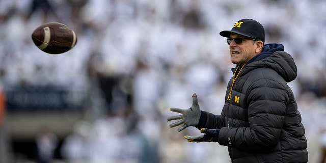 Head coach Jim Harbaugh of the Michigan Wolverines warms up before the game against the Penn State Nittany Lions at Beaver Stadium on Nov. 13, 2021, in State College, Pennsylvania.