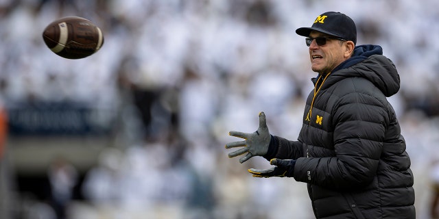 Head coach Jim Harbaugh of the Michigan Wolverines warms up before the game against the Penn State Nittany Lions at Beaver Stadium on Nov. 13, 2021, in State College, Pennsylvania.