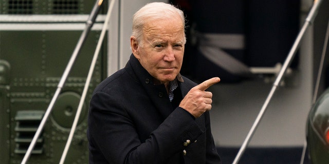 President Biden points to the Oval Office of the White House as he arrives on Marine One on the South Lawn in Washington, Sunday, Nov. 21, 2021, from Wilmington, Del. 
