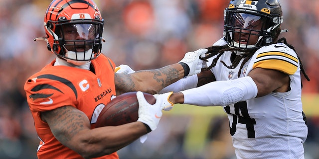 Cincinnati Bengals running back Joe Mixon, 剩下, runs the ball against Pittsburgh Steelers safety Terrell Edmunds (34) 在 NFL 橄榄球比赛的下半场, 星期日, 十一月. 28, 2021, 在辛辛那提. 