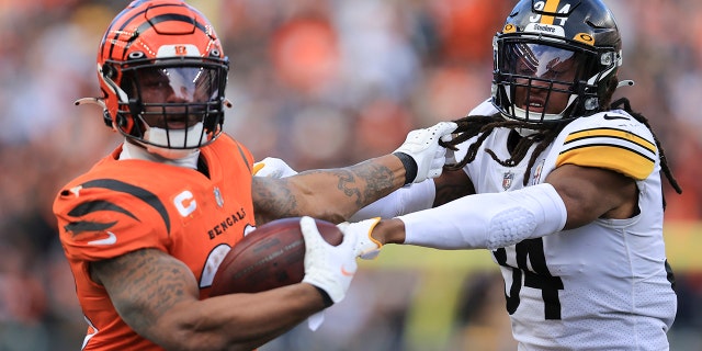 Cincinnati Bengals running back Joe Mixon, 剩下, runs the ball against Pittsburgh Steelers safety Terrell Edmunds (34) 在 NFL 橄榄球比赛的下半场, 星期日, 十一月. 28, 2021, 在辛辛那提.