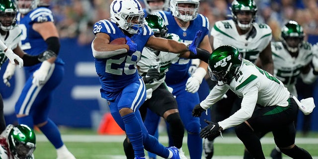 Indianapolis Colts' Jonathan Taylor (28) runs past New York Jets' Ashtyn Davis (21) during the first half of an NFL football game, Thursday, Nov. 4, 2021, in Indianapolis.