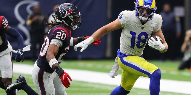 Ben Skowronek (18) of the Los Angeles Rams runs with the ball after a reception as Justin Reid (20) of the Houston Texans pursues at NRG Stadium Oct. 31, 2021 in Houston.