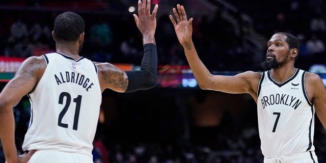 Brooklyn Nets' Kevin Durant, right, and LaMarcus Aldridge celebrate late in the second half of the team's NBA basketball game against the Cleveland Cavaliers, Monday, Nov. 22, 2021, in Cleveland.