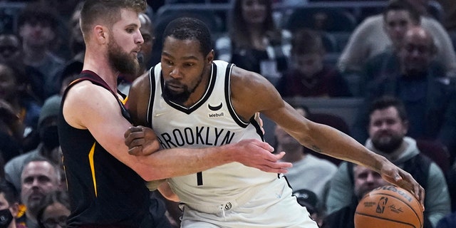 Brooklyn Nets' Kevin Durant, right, drives against Cleveland Cavaliers' Dean Wade during the first half of an NBA basketball game Monday, Nov. 22, 2021, in Cleveland.