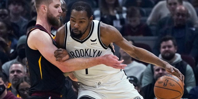 Brooklyn Nets' Kevin Durant, right, drives against Cleveland Cavaliers' Dean Wade during the first half of an NBA basketball game Monday, Nov. 22, 2021, in Cleveland.