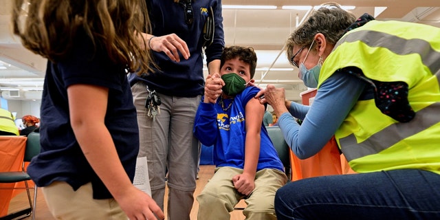 파일 사진: A child reacts while receiving a dose of the Pfizer-BioNTech coronavirus disease (코로나 바이러스 감염증 -19 : 코로나 19) vaccine at Smoketown Family Wellness Center in Louisville, 켄터키, 우리., 십일월 8, 2021. REUTERS/Jon Cherry/File Photo 