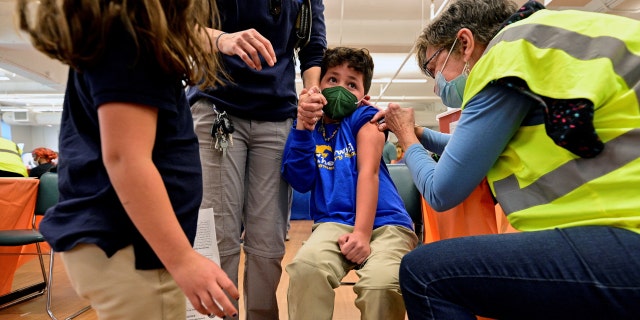 FILE PHOTO: A child reacts while receiving a dose of the Pfizer-BioNTech coronavirus disease (COVID-19) vaccine at Smoketown Family Wellness Center in Louisville, Kentucky, U.S., November 8, 2021. REUTERS/Jon Cherry/File Photo 