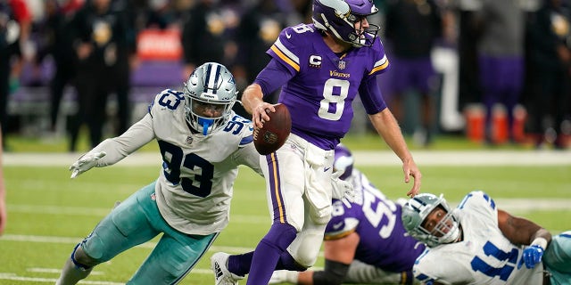 Minnesota Vikings quarterback Kirk Cousins (8) runs from Dallas Cowboys defensive end Tarell Basham (93) during the second half of an NFL football game, Sunday, Oct. 31, 2021, in Minneapolis. The Cowboys won 20-16.