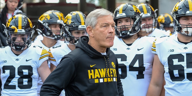 Head coach Kirk Ferentz of the Iowa Hawkeyes waits with the team before the game against the Nebraska Cornhuskers at Memorial Stadium on Nov. 26, 2021, in Lincoln, Nebraska.