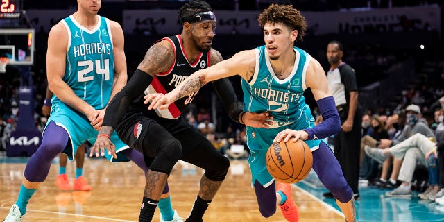 Charlotte Hornets guard LaMelo Ball (2) drives around Portland Trail Blazers forward Robert Covington (33) after Hornets center Mason Plumlee (24) set a screen Oct. 31, 2021, in Charlotte, N.C.