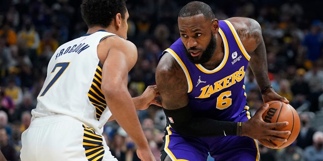 Los Angeles Lakers' LeBron James (6) is defended by Indiana Pacers' Malcolm Brogdon (7) during the first half of an NBA basketball game Wednesday, Nov. 24, 2021, in Indianapolis.