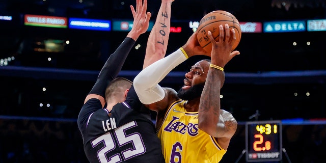 Los Angeles Lakers forward LeBron James (6) is defended by Sacramento Kings center Alex Len (25) during the first half of an NBA basketball game in Los Angeles, Friday, Nov. 26, 2021.