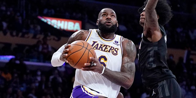 Los Angeles Lakers forward LeBron James, links, shoots as Houston Rockets guard Kevin Porter Jr. defends during the first half of an NBA basketball game Sunday, Okt.. 31, 2021, in Los Angeles. 