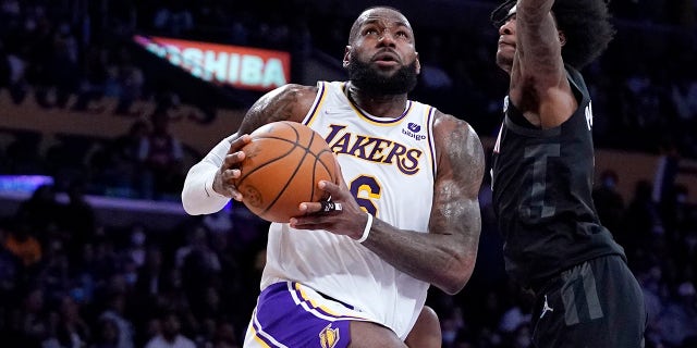 Los Angeles Lakers forward LeBron James, left, shoots as Houston Rockets guard Kevin Porter Jr. defends during the first half of an NBA basketball game Sunday, Oct. 31, 2021, in Los Angeles. 