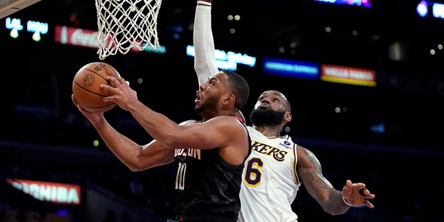 Houston Rockets guard Eric Gordon, left, shoots as Los Angeles Lakers forward LeBron James defends during the second half of an NBA basketball game Sunday, Oct. 31, 2021, in Los Angeles.