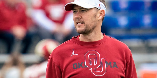 Head coach Lincoln Riley of the Oklahoma Sooners talks to players during warmups before taking on the Kansas Jayhawks at David Booth Kansas Memorial Stadium Oct. 23, 2021 ローレンスで, Kan.
