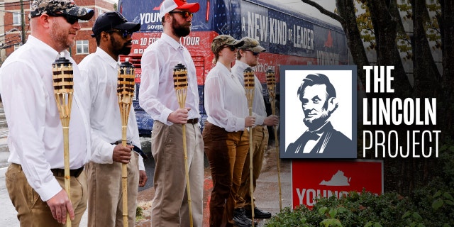 Un petit groupe de manifestants habillés en "Unir la droite" Des amateurs de rassemblement avec des torches tiki se tiennent sur un trottoir alors que le candidat républicain au poste de gouverneur de Virginie Glenn Youngkin arrive dans son bus pour un événement de campagne dans un restaurant mexicain à Charlottesville, Virginie, États-Unis, le 29 octobre 2021. REUTERS / Jonathan Ernst