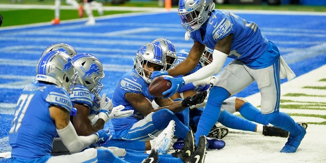 Detroit Lions cornerback Amani Oruwariye, 对, celebrates his interception with teammates during the first half of an NFL football game against the Chicago Bears, 星期四, 十一月. 25, 2021, in Detroit.