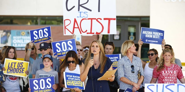 Amy Carney speaks on behalf of parents during a protest against critical race theory being taught at Scottsdale Unified School District before a digital school board meeting at Coronado High School in Scottsdale on May 24, 2021.