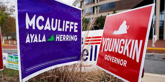 Campaign signs for Democrat Terry McAuliffe and Republican Glenn Youngkin stand together on the last day of early voting in the Virginia gubernatorial election in Fairfax, Virginia, Ott. 30, 2021.