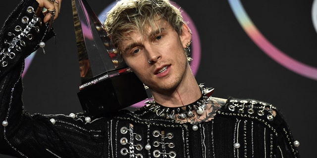 Machine Gun Kelly, winner of the award for favorite rock artist poses in the press room at the American Music Awards on Sunday, Nov. 21, 2021, at Microsoft Theater in Los Angeles. 