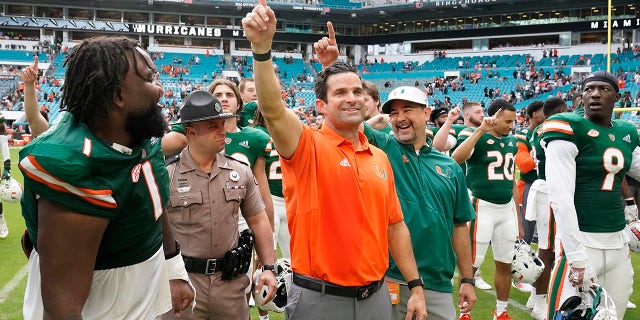 Miami head coach Manny Diaz, center, celebrates with players after Miami beat Georgia Tech, 33-30, on Saturday, Nov. 6, 2021, in Miami Gardens, Florida.