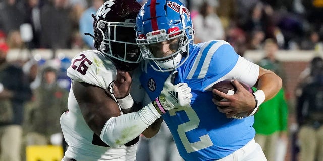 Texas A&M defensive back Demani Richardson (26) attempts to strip the ball away from Mississippi quarterback Matt Corral (2) during the first half of an NCAA college football game, Saturday, Nov. 13, 2021, in Oxford, Miss.