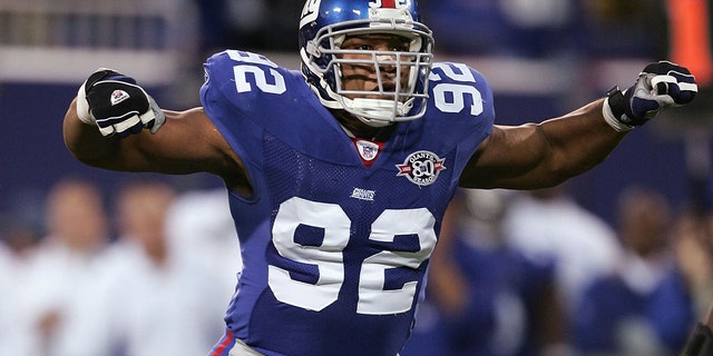 El ala defensiva de los New York Giants Michael Strahan #92 celebra un saco del mariscal de campo de los Chicago Bears Craig Krenzel #16 el 7 de noviembre de 2004 en el Giants Stadium en East Rutherford, Nueva Jersey.