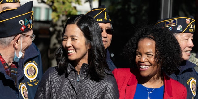 Boston Mayor-elect Michelle Wu, left, and acting Mayor Kim Janey talk with members of the Boston Chinatown Post of the American Legion following a Veterans Day parade, Saturday, Nov. 6, 2021, in Boston. Wu became Boston’s first female and Asian American mayor on Tuesday. (AP Photo/Michael Dwyer)