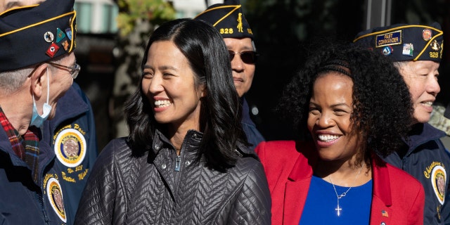 Boston Mayor-elect Michelle Wu, left, and acting Mayor Kim Janey talk with members of the Boston Chinatown Post of the American Legion following a Veterans Day parade, Saturday, Nov. 6, 2021, in Boston. Wu became Boston's first female and Asian American mayor on Tuesday. (AP Photo/Michael Dwyer)